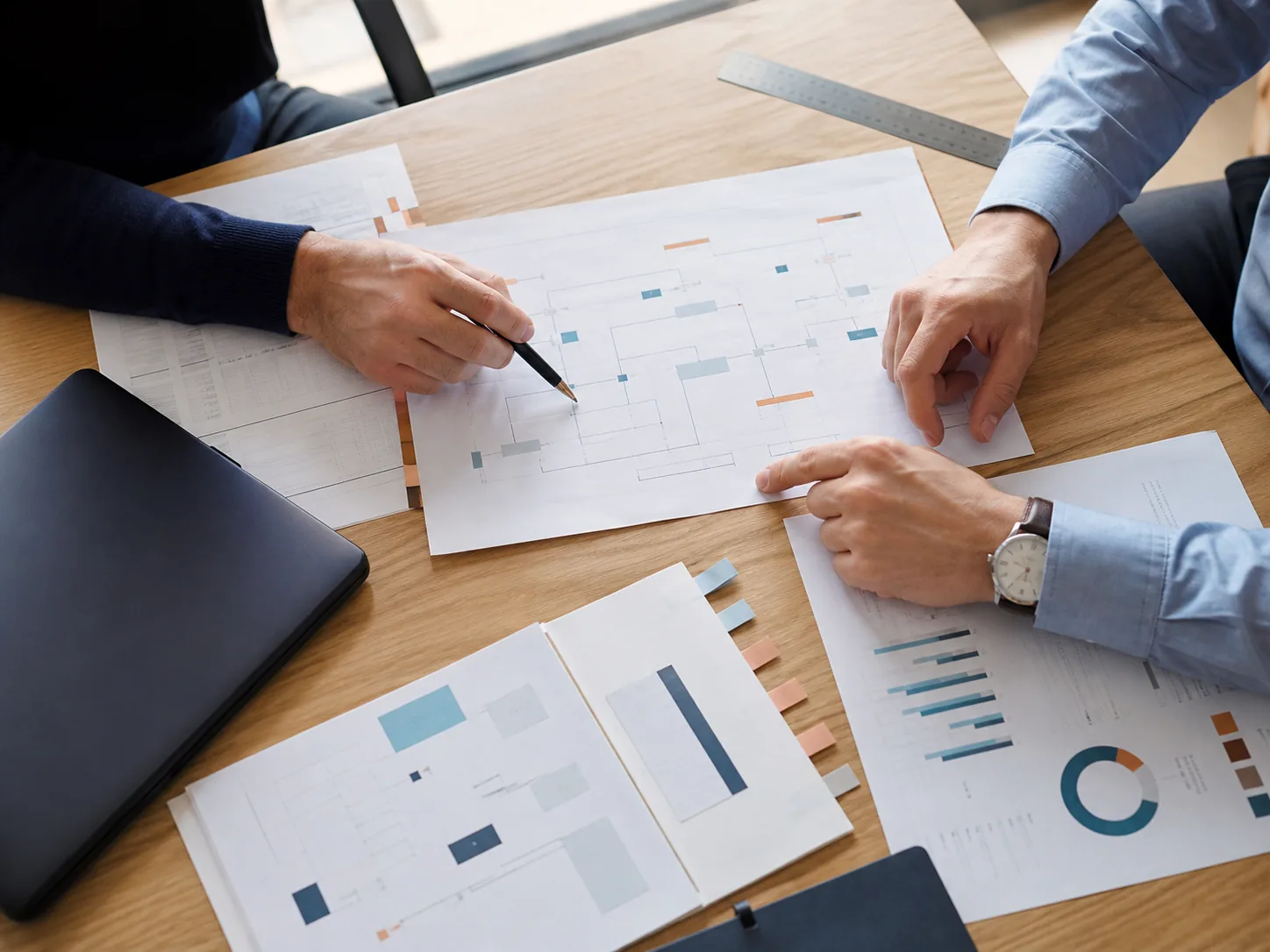 Professionnels examinant ensemble des documents et un schéma de contrôle